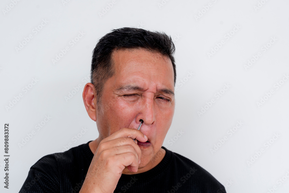 Middle-aged Asian man with low pain tolerance, reacting in pain after accidentally cutting the tip of his index finger, isolated on white background