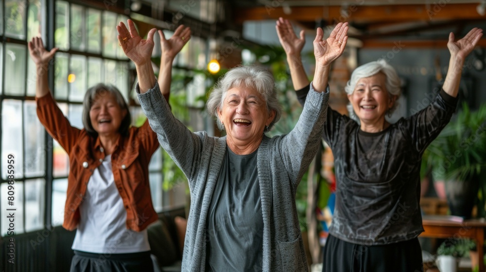 Fototapeta premium Joyful gathering of three elderly women celebrating with arms raised in a cozy cafe, evoking feelings of friendship and happiness, warm tones dominate.