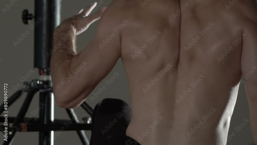 During the slow motion theatrical movements of the male muscular acrobatic dancer, back and arm muscles are seen. During the slow motion theatrical movements of the male muscular acrobatic dancer, back and arm muscles are seen.