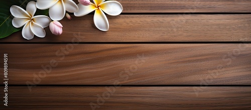 Top down view of a spa environment featuring a plumeria flower gracefully placed on a wooden table creating an inviting copy space image