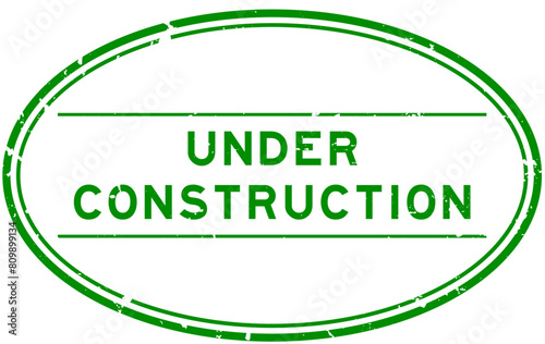 Grunge green under construction word oval rubber seal stamp on white background