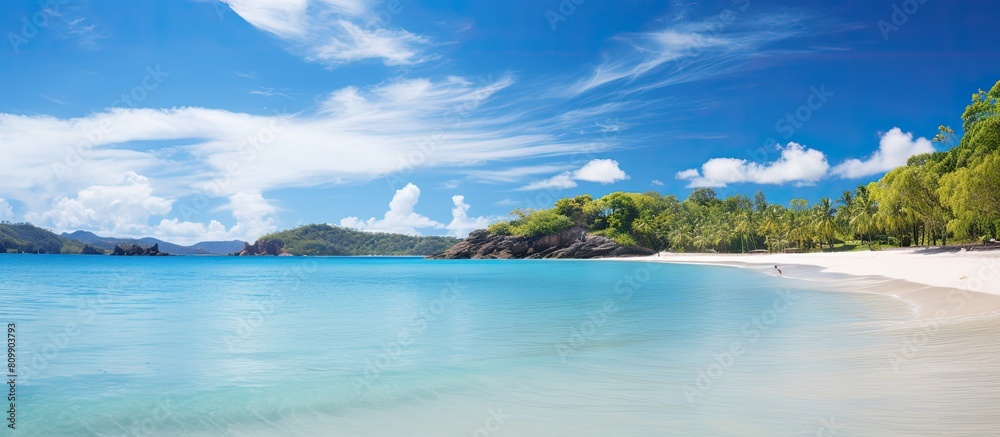 An idyllic sandy beach paradise with a blue lagoon transparent water fresh green trees and no people The sunny weather and scattered clouds make Anse Lazio the perfect copy space image