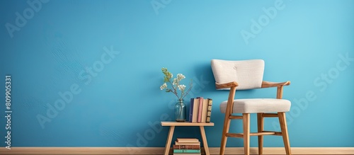 An inviting setup with a wooden step stool complemented by decorative items books and an armchair positioned against a vibrant blue wall providing ample copy space for the image 170 characters photo