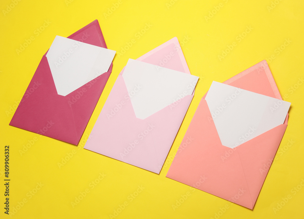 Pink envelopes with white blank letters on a yellow background. Creative layout Pink envelopes with white blank letters on a yellow background. Creative layout