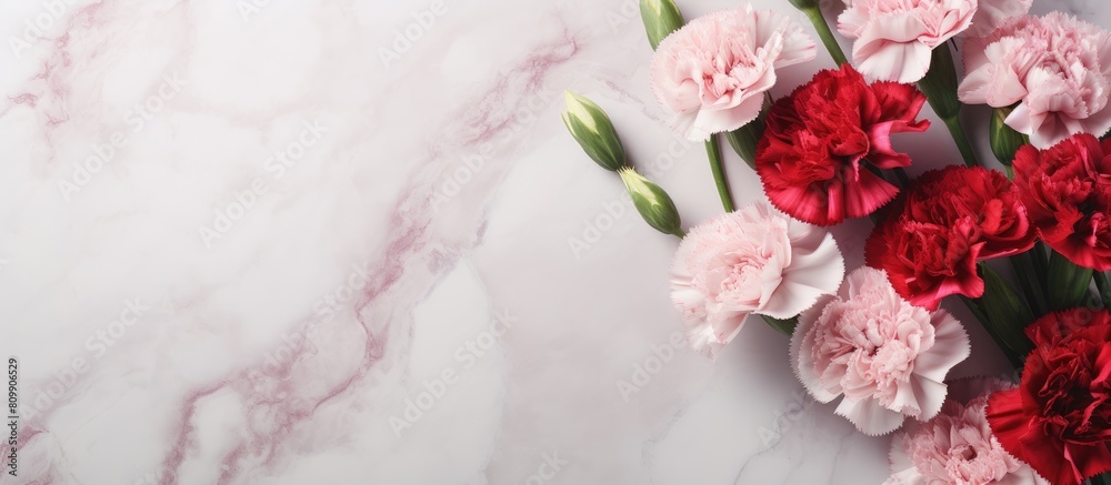 Top view of a stunning bouquet of pink and red carnations on a marble table This beautiful arrangement is perfect for Mother s Day or Valentine s Day with a flat lay design and plenty of copy space f Top view of a stunning bouquet of pink and red carnations on a marble table This beautiful arrangement is perfect for Mother s Day or Valentine s Day with a flat lay design and plenty of copy space f