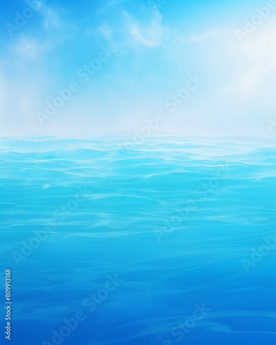 An endless ocean with clear blue water and a bright blue sky with few clouds.