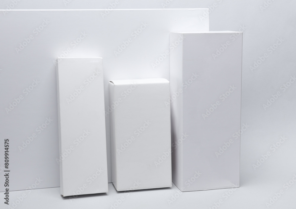 Different shapes of white cardboard boxes for presentation products on white background. Mockup for design. Different shapes of white cardboard boxes for presentation products on white background. Mockup for design.