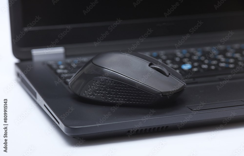 Wireless black pc mouse on laptop keyboard close-up Wireless black pc mouse on laptop keyboard close-up