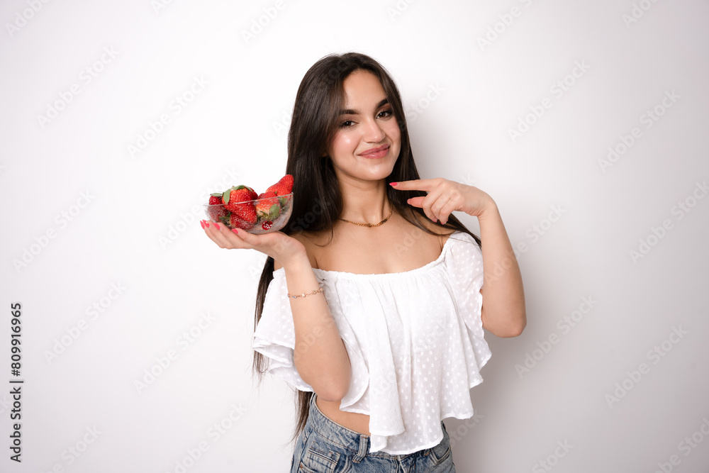 Beautiful woman eating strawberries isolated on white background Beautiful woman eating strawberries isolated on white background