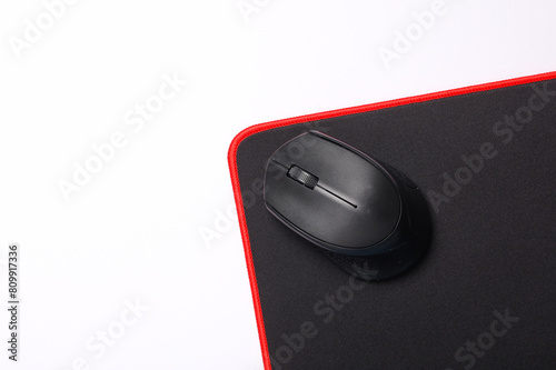 Black PC mouse with PC mouse pad on a black background