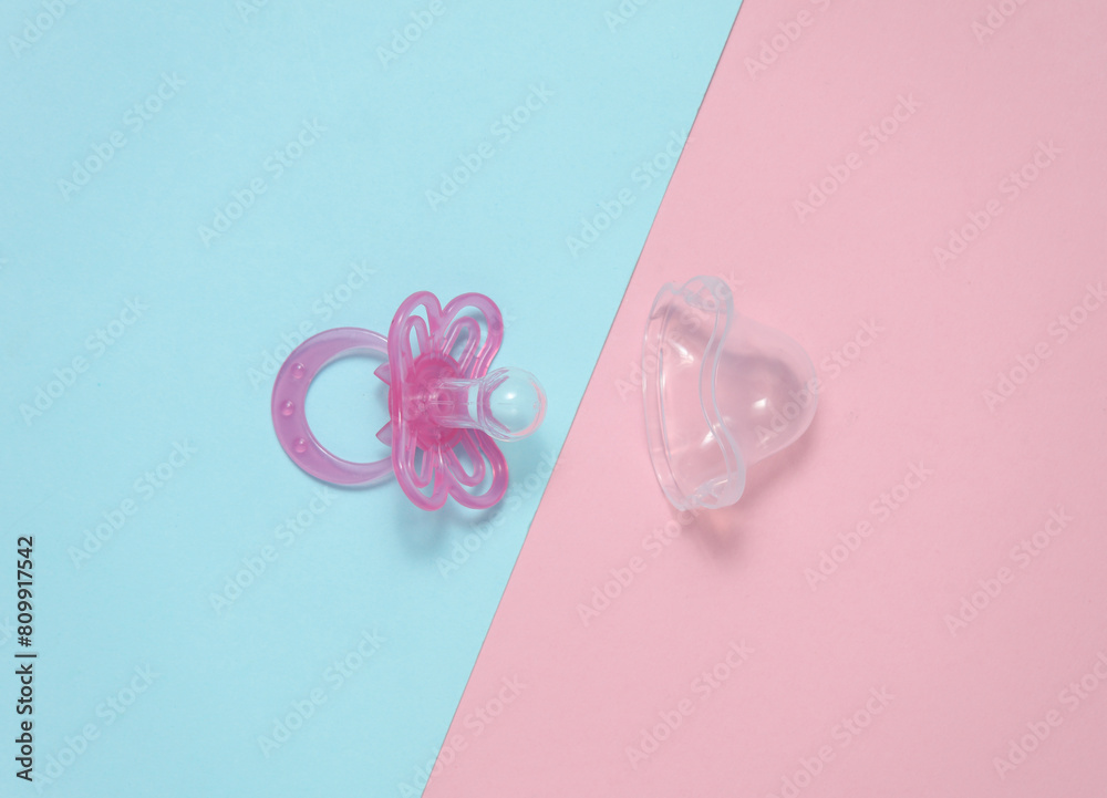 Baby pacifier on a blue pink background Baby pacifier on a blue pink background