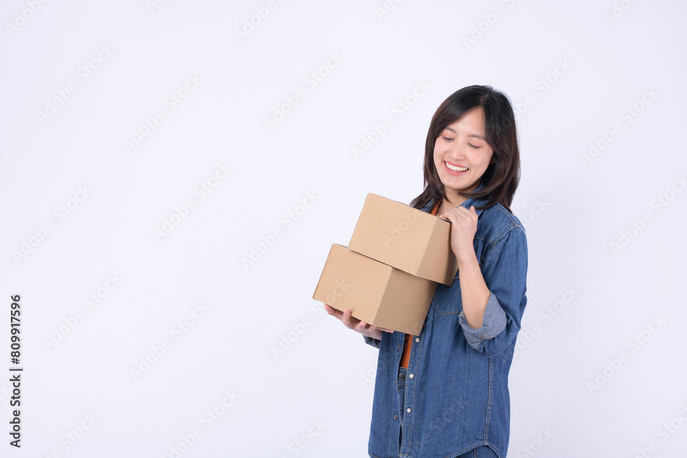 young asian woman wearing orange t-shirt and denim shirt holding parcel box isolated on white studio background, Delivery courier and shipping service concept. young asian woman wearing orange t-shirt and denim shirt holding parcel box isolated on white studio background, Delivery courier and shipping service concept.