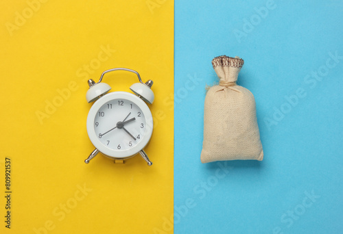 Mini burlap pouch and alarm clock on a blue yellow background