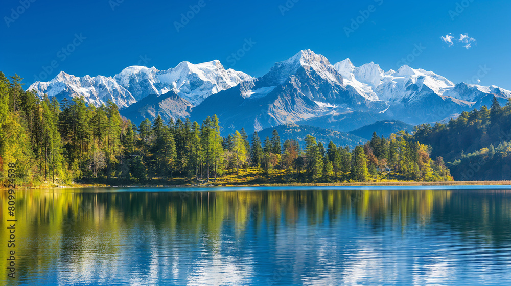 A majestic mountain range with snow-capped peaks, clear blue skies and a calm lake in the foreground.