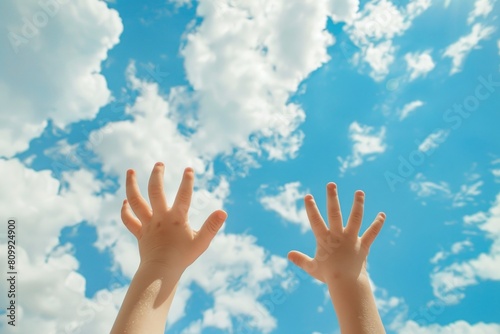 Hands To Sky. Siblings reaching for sunshine in summer, under blue skies at the beach