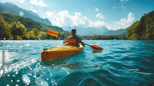 A man is actively paddling a kayak in the water. photo