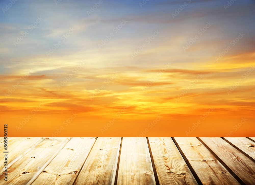 Wooden table on sky background and sunset light