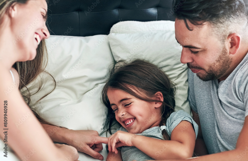 Love, laughing and happy family in bed for tickle fun, playing or bonding at home together. Support, security and girl with funny parents in bedroom for wake up games with safety, care or protection Love, laughing and happy family in bed for tickle fun, playing or bonding at home together. Support, security and girl with funny parents in bedroom for wake up games with safety, care or protection