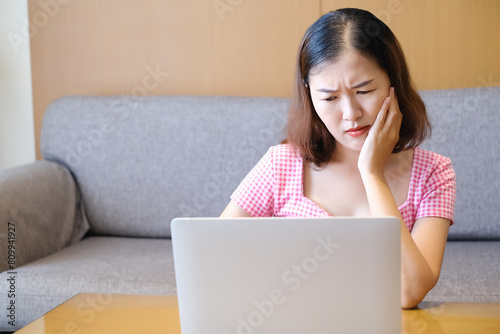 Asia woman headache because playing or working with laptop, work form home