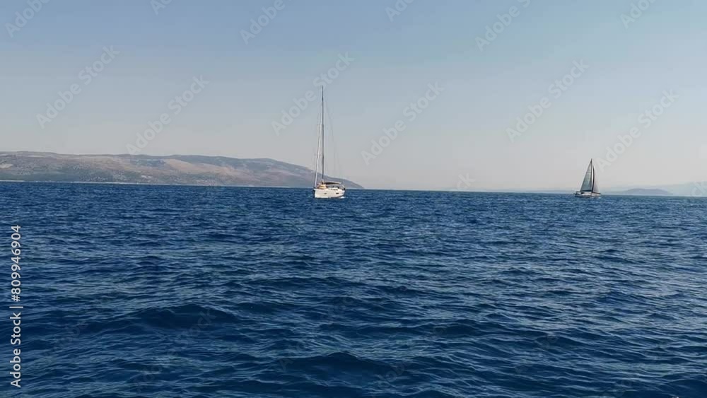 Yacht during her sailing on the coastline background on a sunny summer day. Yacht during her sailing on the coastline background on a sunny summer day.