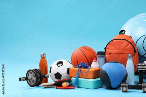 Many different sports equipment on light blue background, space for text