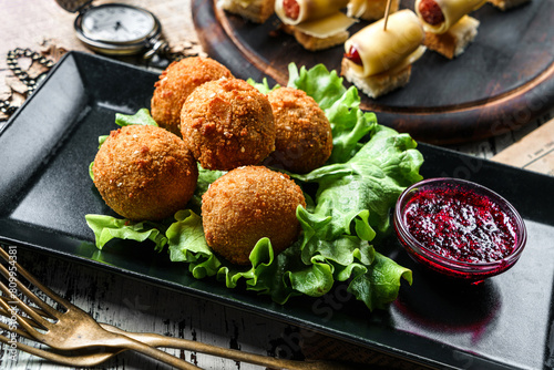 Deep fried cheese balls breaded and deep fried with berries sauce on rustic background. Appetizer snack  close up