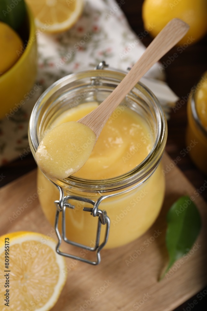 Delicious lemon curd in glass jar, spoon and fresh citrus fruits on table Delicious lemon curd in glass jar, spoon and fresh citrus fruits on table