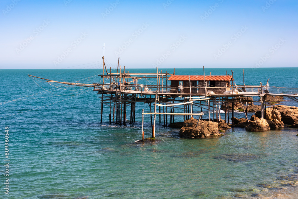 Traditional wooden fishing house with a net near sea coast Traditional wooden fishing house with a net near sea coast