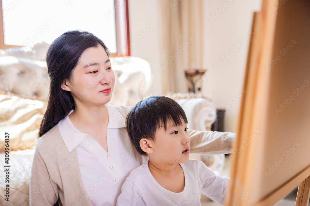 Mother and son at a drawing game in the living room Mother and son at a drawing game in the living room