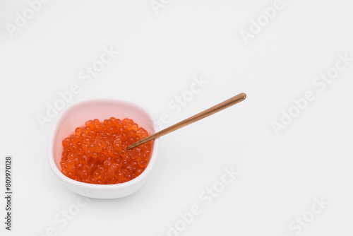 red caviar in a saucer on a white background