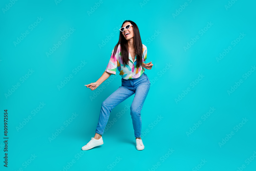 Photo of glad cheerful positive woman wear stylish print clothes dance weekend good mood isolated on cyan color background Photo of glad cheerful positive woman wear stylish print clothes dance weekend good mood isolated on cyan color background