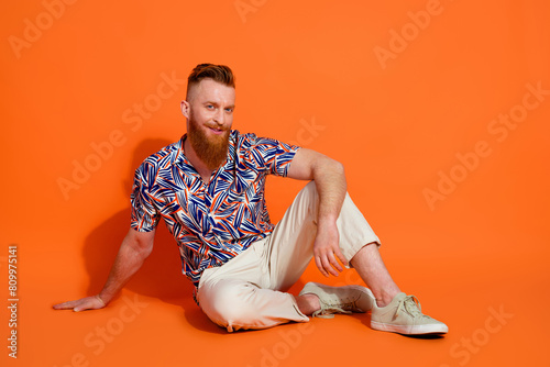 Photos Full size photo of cheerful confident man wear stylish shirt white pants sitting