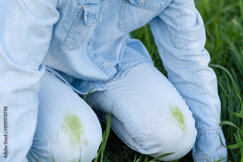  An unrecognizable person showing dirty grass stains on clothes sitting on the grass, outdoors. top view