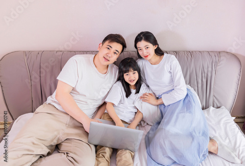 A family of three in the bed in the bedroom