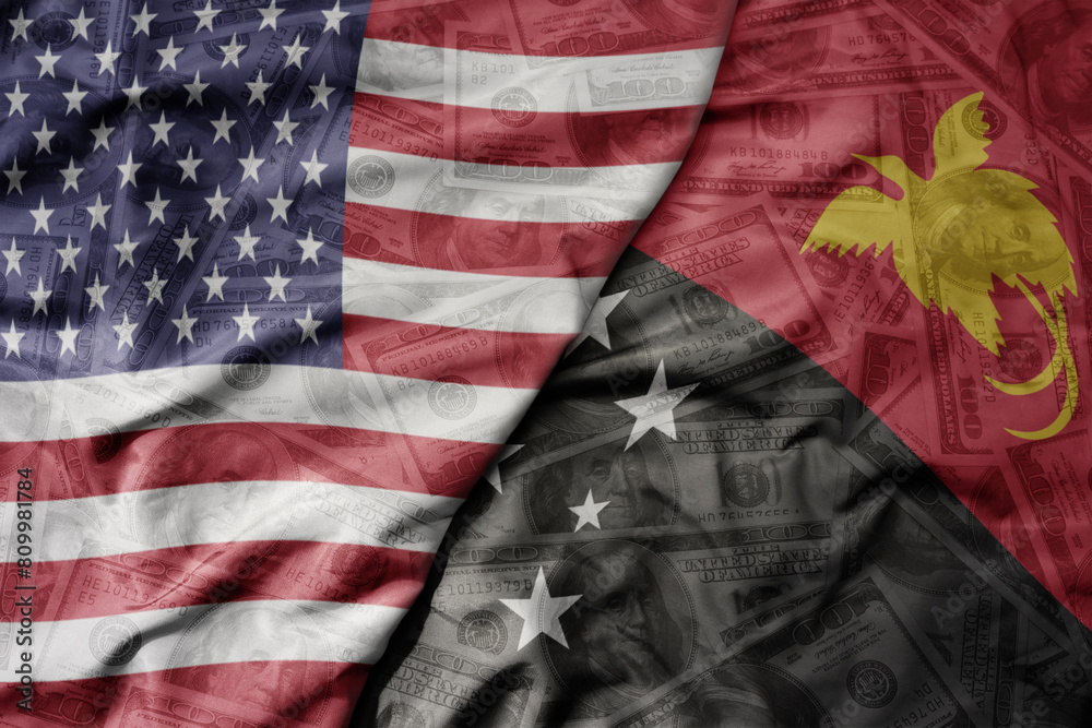 big waving colorful flag of united states of america and national flag of Papua New Guinea on the dollar money background. finance concept. big waving colorful flag of united states of america and national flag of Papua New Guinea on the dollar money background. finance concept.