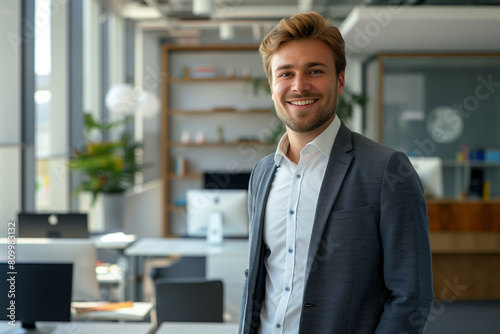 Wallpaper Mural Young businessman with a smile on his face, looking confidently into the camera, presenting himself as an elegant corporate leader. His attitude exudes determination in achieving business goals. Torontodigital.ca