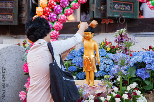 Pouring the water on the Buddha statue for the wish in the Buddhist temple photo