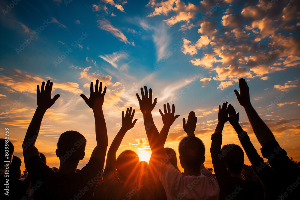 A group of people with their hands raised to the sky, watching the sunset with an expression of reflection and gratitude, devoting themselves to a moment of reflection and peace in the face of nature.