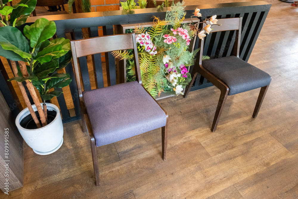 Fototapeta premium Wooden chairs and tables with green forest wall,flower and red brick wall in Relax restaurant or cafe.