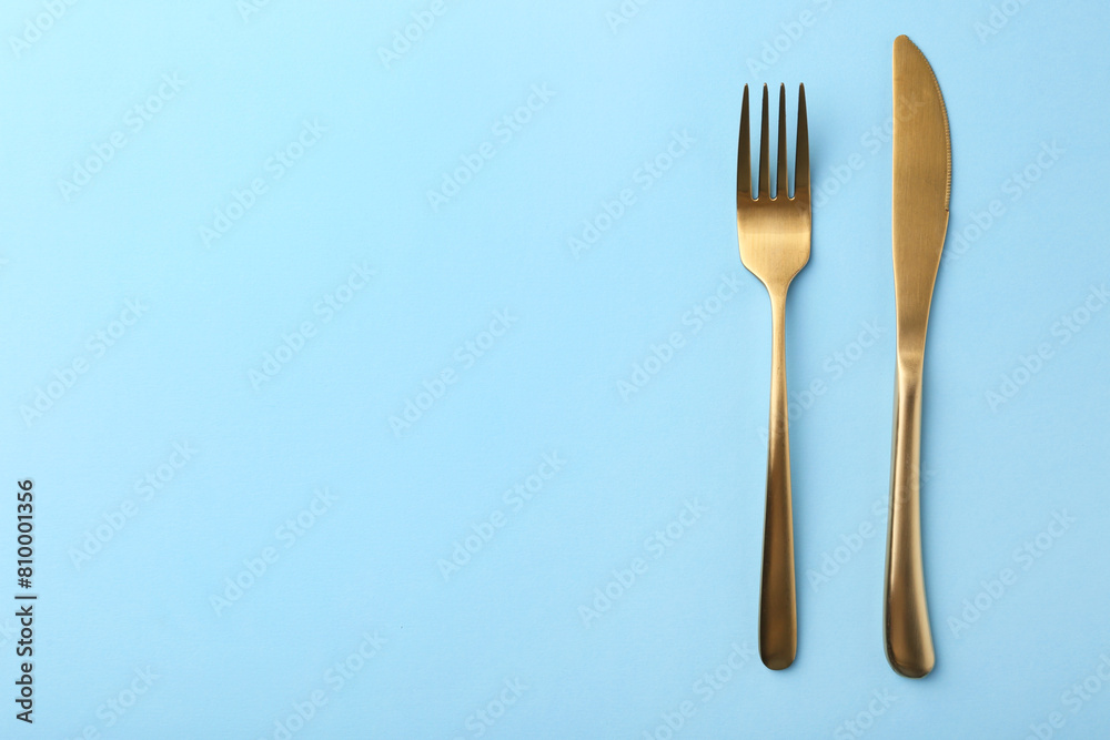 Stylish cutlery on light blue table, top view. Space for text Stylish cutlery on light blue table, top view. Space for text