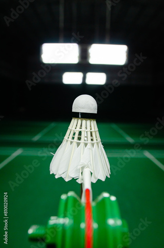 The shuttlecock is floating in a green badminton court net. background shot in low light © tewpai