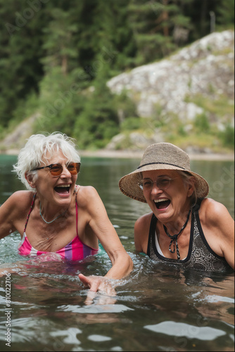 Two elderly women wild swimmers laughing by a lake