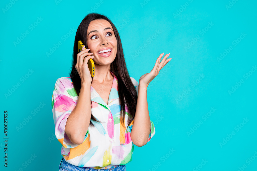 Photo of pretty young woman talk telephone empty space wear shirt isolated on teal color background Photo of pretty young woman talk telephone empty space wear shirt isolated on teal color background