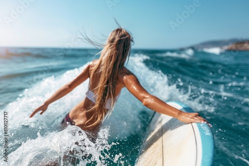 Female surfer riding wave in ocean photo