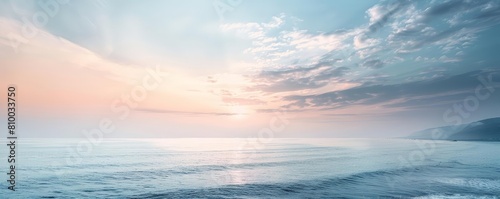 minimalist coastal landscape with soft sunset hues featuring a white cloud and blue sky © YOGI C
