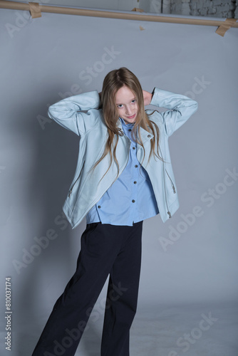 Child model with a hint of playfulness, adorned in fashionable attire. Resonates with the lively spirit of kids' fashion.