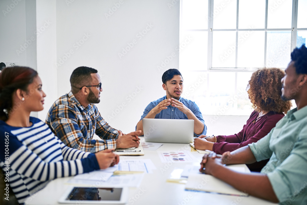 Startup, laptop or people in meeting speaking of paperwork, feedback review or partnership together. Development, staff or designers talking for teamwork or planning in conversation for project brief