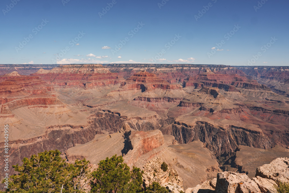 Panoramic view of Grand Canyon, Arizona, USA. Capturing stunning layers of red rock, deep gorges, greenery, and clear blue skies. Popular tourist destination renowned for immense scale. Panoramic view of Grand Canyon, Arizona, USA. Capturing stunning layers of red rock, deep gorges, greenery, and clear blue skies. Popular tourist destination renowned for immense scale.