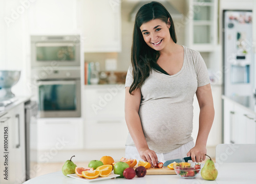 Woman  pregnant and cutting fruit in portrait  nutrition and vitamin for growth of baby. Female person  organic and vegan snack or home for health  cooking and healthy diet for maternity in kitchen