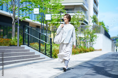 ショッピングバッグを持って街を歩く女性 © maru54